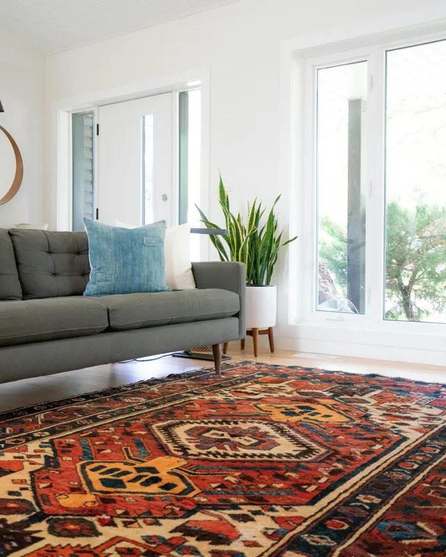 A living room with a couch and a rug on the floor.